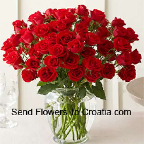 51 Roses Rouges avec quelques fougères dans un vase en verre