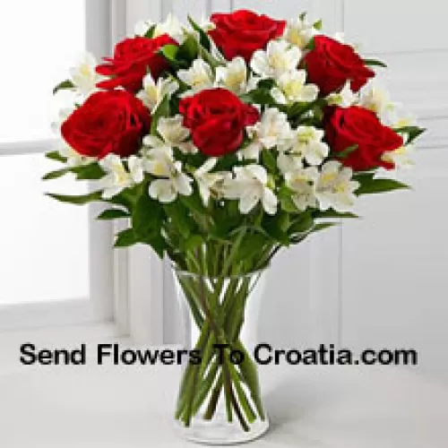 7 Roses rouges avec des fleurs blanches assorties et des remplisseurs dans un vase en verre